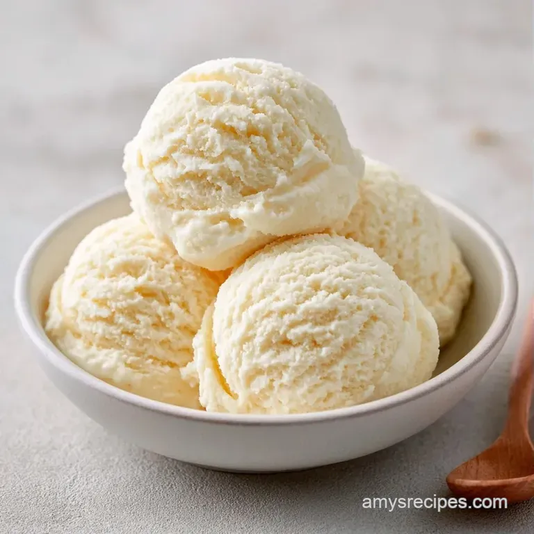 Elegant ivory-colored frozen scoops on a dark slate platter, garnished with a fresh mint leaf and honey drizzle.