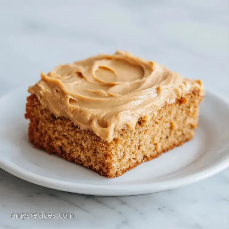 A golden cake slice on a white plate, drizzled with creamy peanut sauce and topped with a single fresh raspberry.