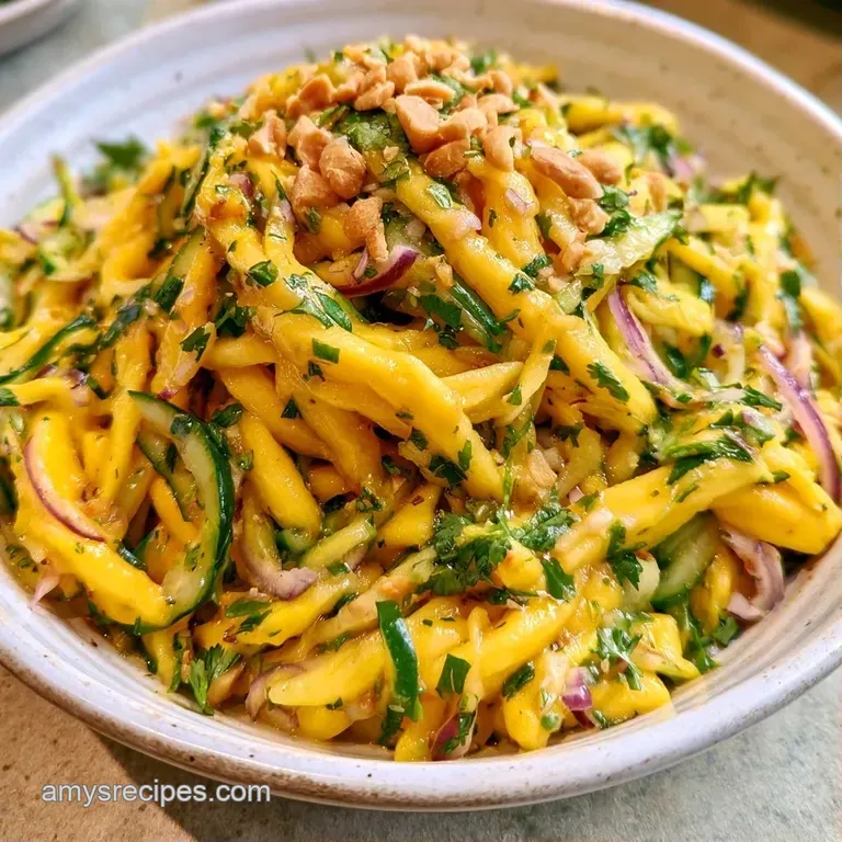 Fresh mango cubes and red onion slivers artfully plated on a ceramic dish with a sprinkle of sesame seeds and lime.